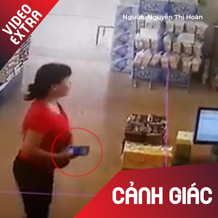 Nguoi phu nu cuom dien thoai khi nhan vien co mat ke ben hinh anh