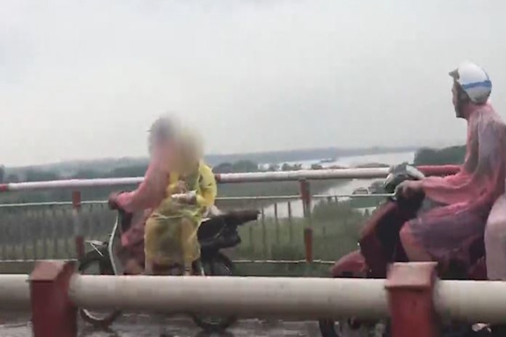 Cau be ngoi chenh venh an sang tren xe may day nguy hiem hinh anh