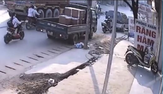 Xe may bi container tong trung, 2 nguoi may man thoat chet hinh anh