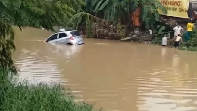Oto 'lac troi' giua song duoc nguoi dan keo vao hinh anh