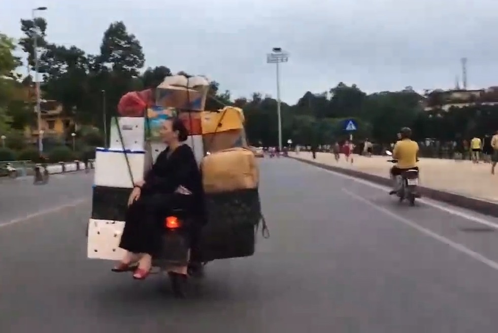 Nguoi phu nu ngoi cheo leo sau xe may khien nguoi xem ai ngai hinh anh