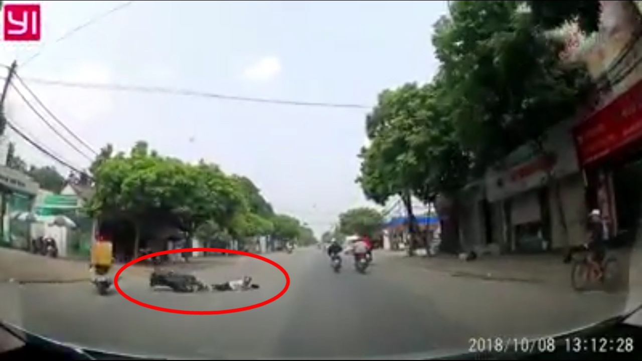 Dang chay xe, nguoi dan ong tu te truot dai giua duong hinh anh