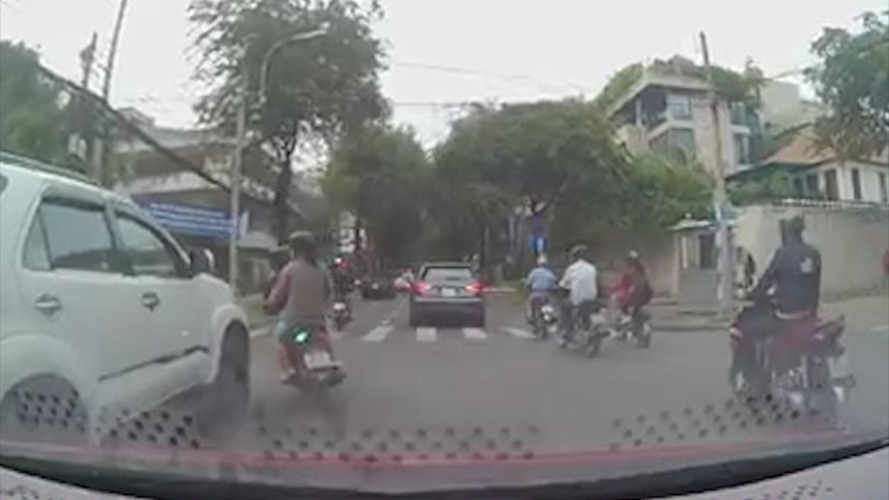 Xe may dot ngot tat dau oto, hai nguoi nga ra duong hinh anh