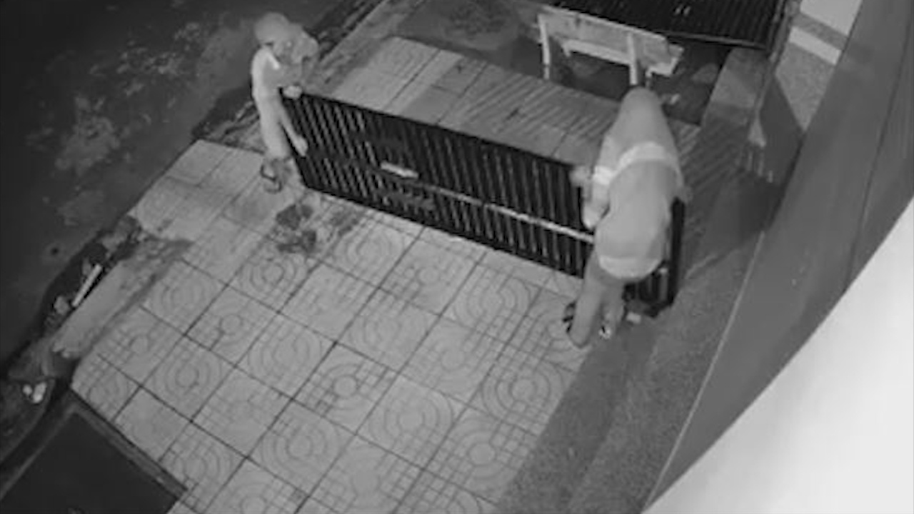 Hai nguoi dan ong trom bac dat xe truoc cua nha hinh anh