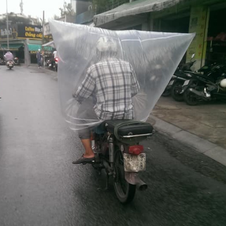 Khong co ao mua, nguoi dan ong trum bao nylon kin mit khi chay xe hinh anh
