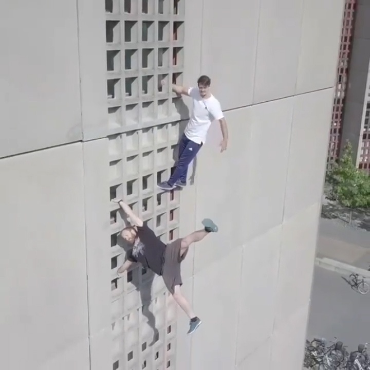 Hai chang trai tu tay leo len noc toa nha cao tang hinh anh