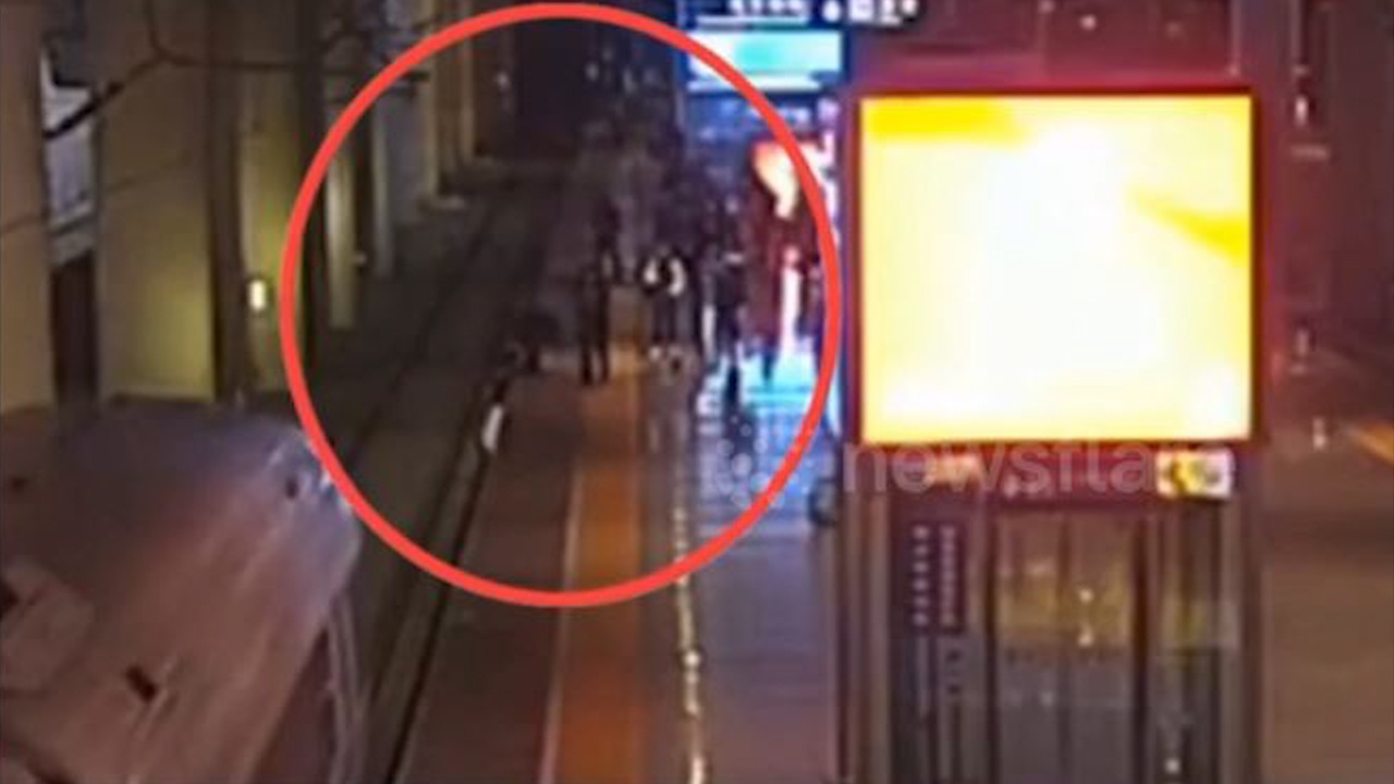 Nhay xuong duong ray de doa ban trai, co gai Trung Quoc suyt gap nan hinh anh