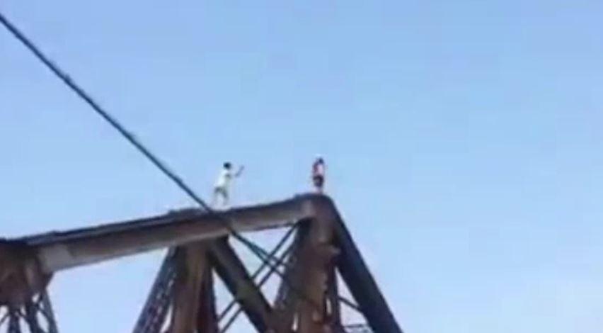 Hai thanh nien nhao lon nguy hiem tren dinh cau Long Bien hinh anh