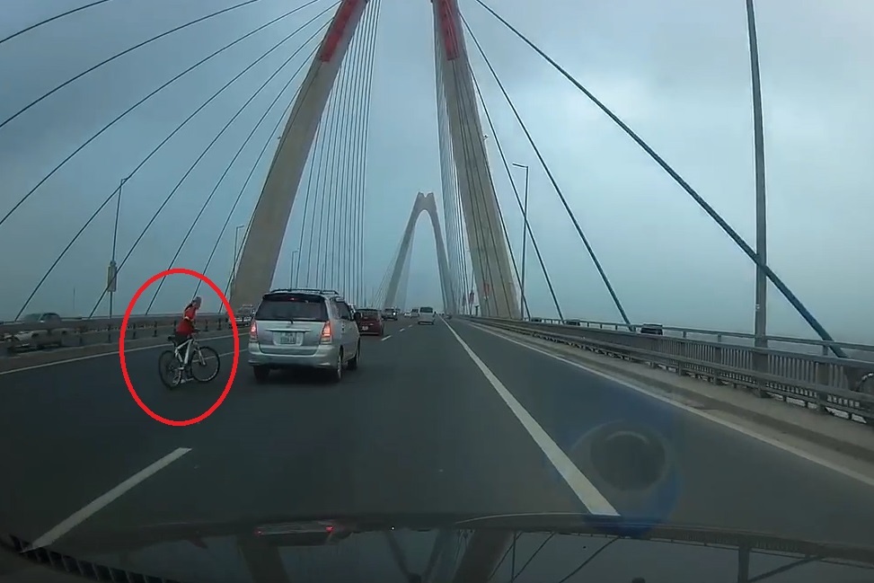 Oto chay nhanh danh lai tranh xe dap dat bo tren cau Nhat Tan hinh anh