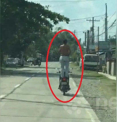 Nguoi dan ong dung tren yen xe may, chay bon bon tren duong hinh anh