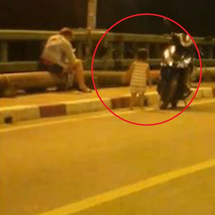 Nguoi me mai bam dien thoai de con choi giua cau day xe co hinh anh