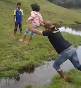 Cha be con te sap mat khi co gang nhay qua vung nuoc hinh anh