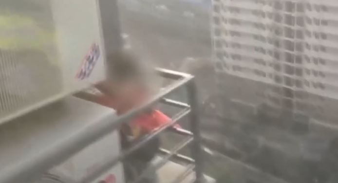 Be trai leo ra ban cong tang 20 di tim cha hinh anh