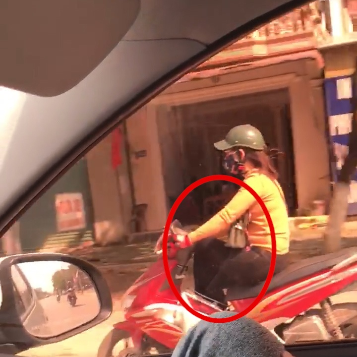 Vat cheo ca hai chan sang mot ben khi dang cam lai xe tay ga hinh anh