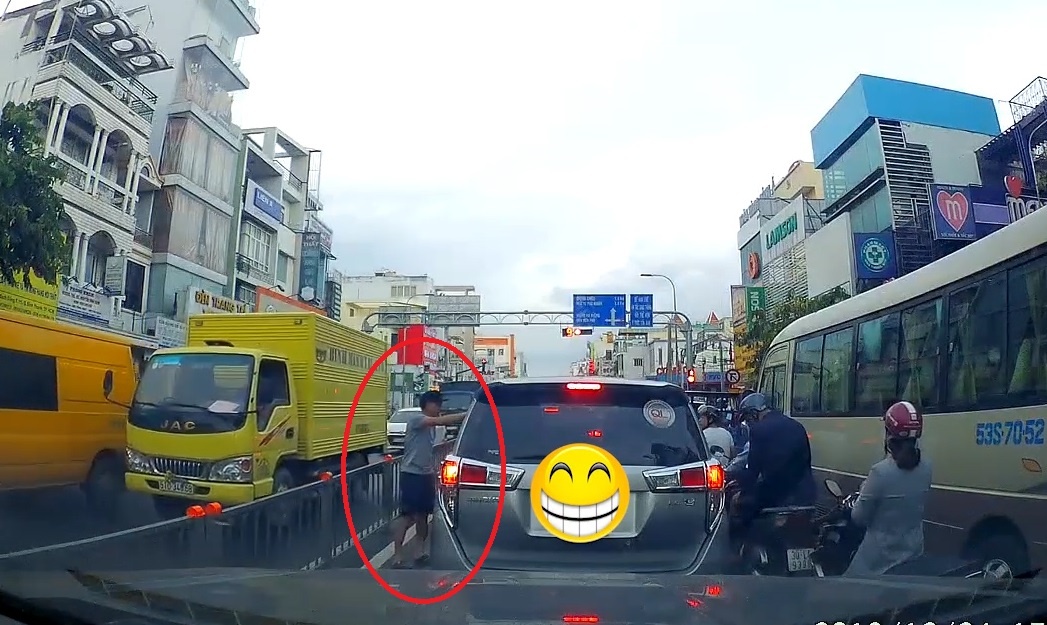 Ngoi trong oto vut rac ra pho, bi nguoi di duong nem lai vao trong xe hinh anh