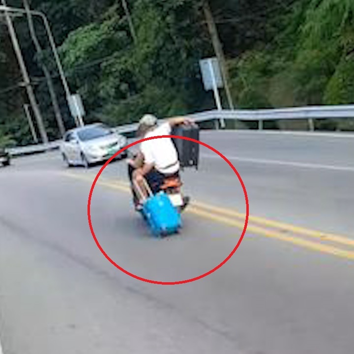 Ngoi sau xe may, keo vali lao dao tren duong hinh anh