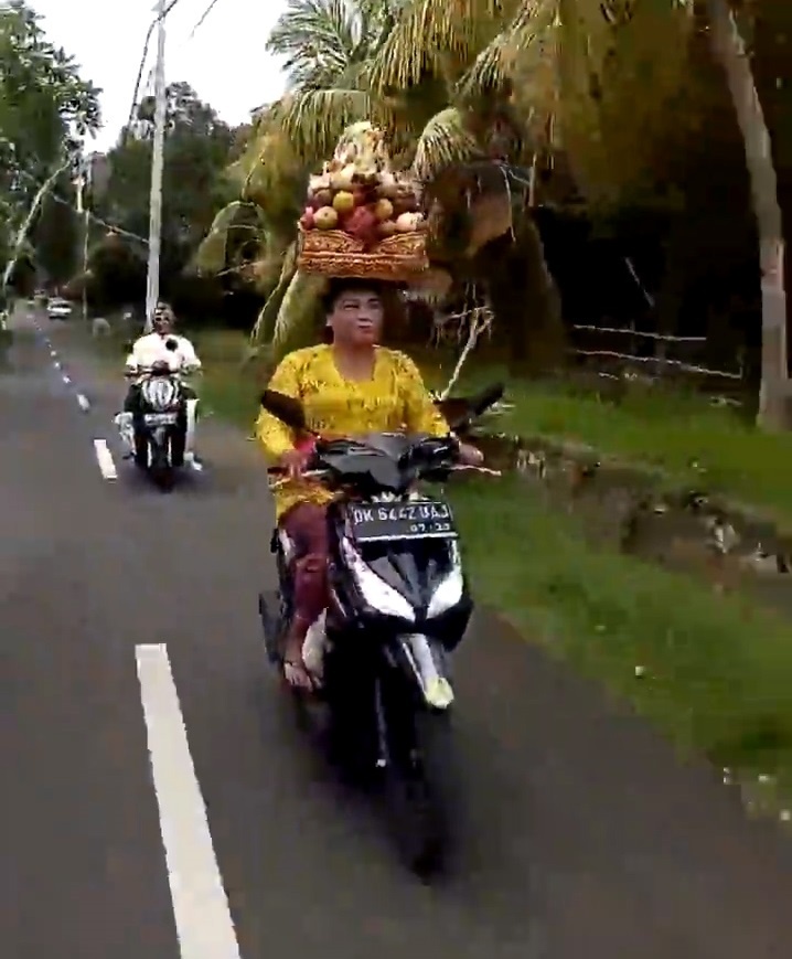 Nguoi phu nu doi gio trai cay tren dau, chay bon bon tren duong hinh anh