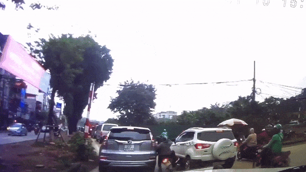 Di vao giua 2 oto, xe may loang choang roi te giua duong hinh anh