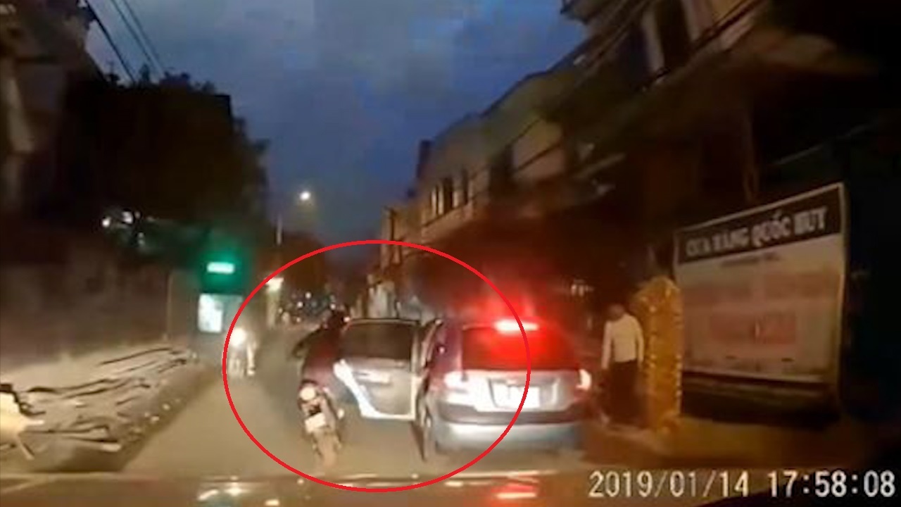 Tai xe oto mo cua xe vo y khien xe may nga nhao ra duong hinh anh