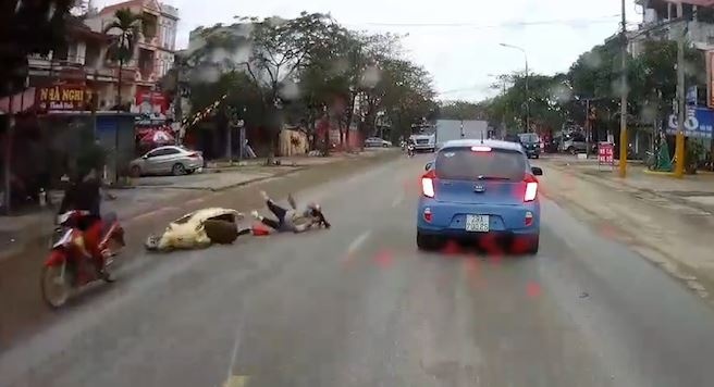 Nguoi phu nu dieu khien xe may tu te lan ra duong hinh anh