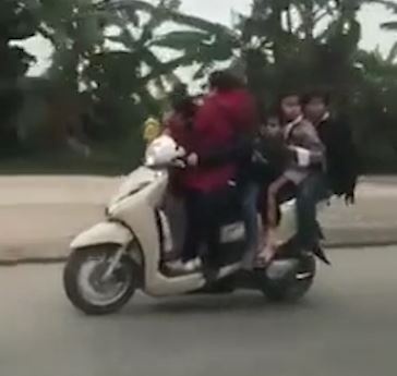 Nguoi phu nu di xe may nhoi nhet 5 dua tre luu thong tren duong hinh anh