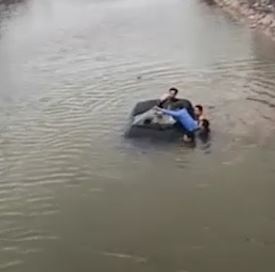 Nguoi dan loi xuong song de giai cuu tai xe mac ket trong oto hinh anh