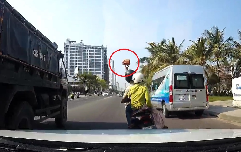 Xe may cam gach nem vo kinh oto dang chay tren duong hinh anh