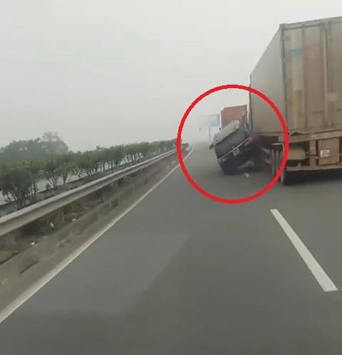 Oto chay nhu ngu gat, va vao xe container roi lao len dai phan cach hinh anh