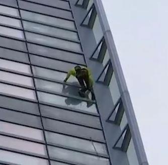 Nguoi dan ong leo len toa nha cao chot vot ma khong co do bao ho hinh anh