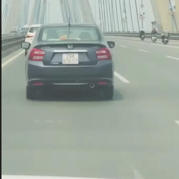 Thanh nien lai xe hoi buong vo lang de choi game tren smartphone hinh anh