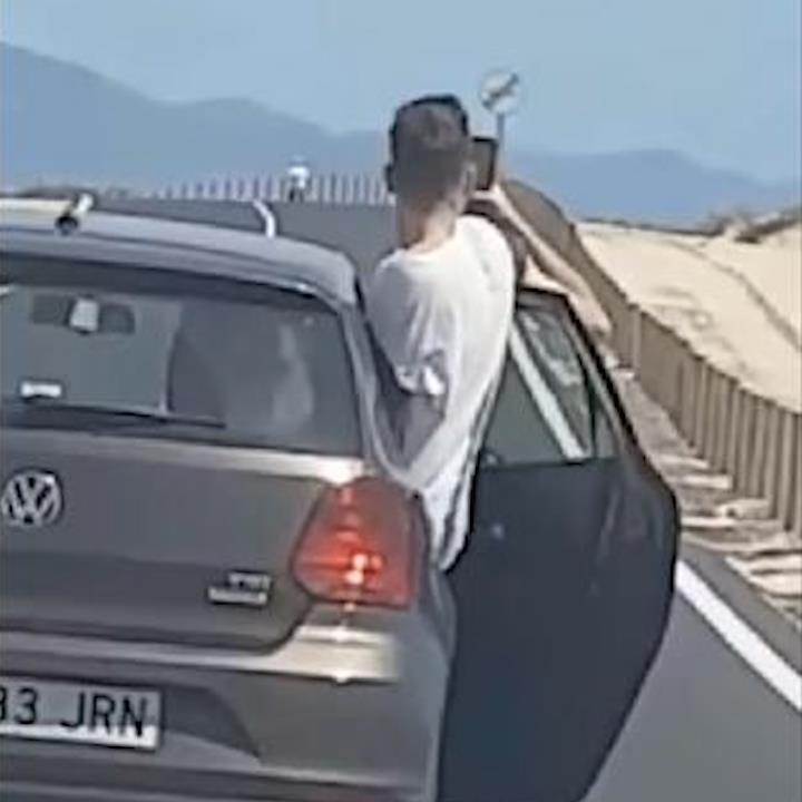 Bat chap nguy hiem, chang trai mo cua oto dang chay de selfie hinh anh