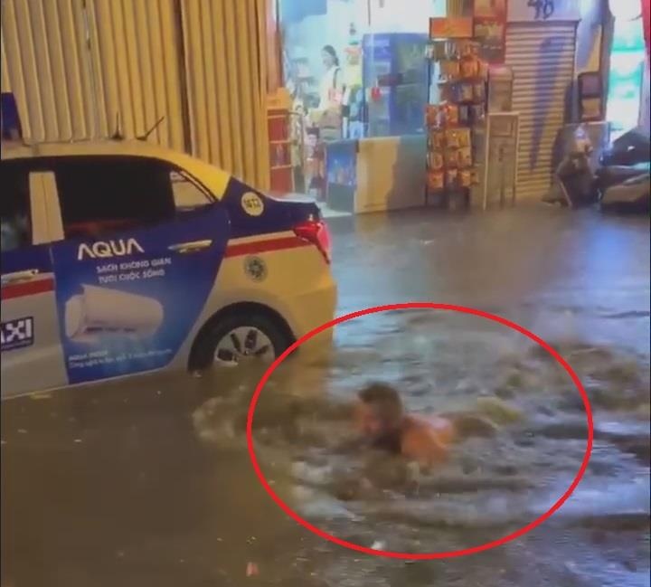 Khach Tay thich thu boi loi giua duong pho ngap nuoc o Ha Noi hinh anh
