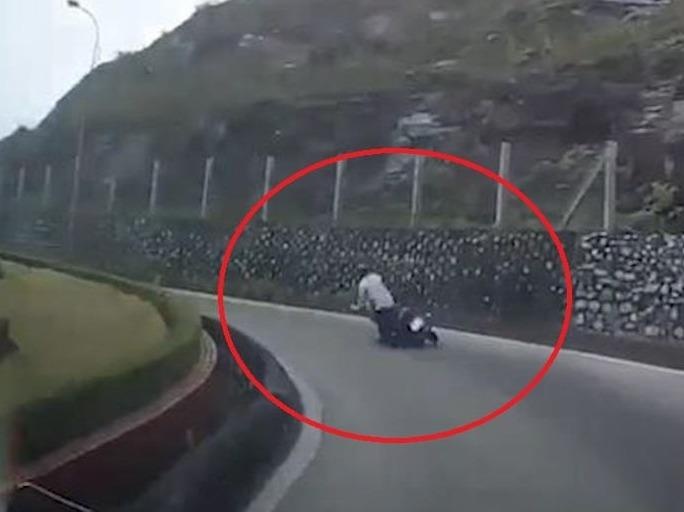 Om cua chi bang mot tay, xe may nga nhao xuong duong hinh anh