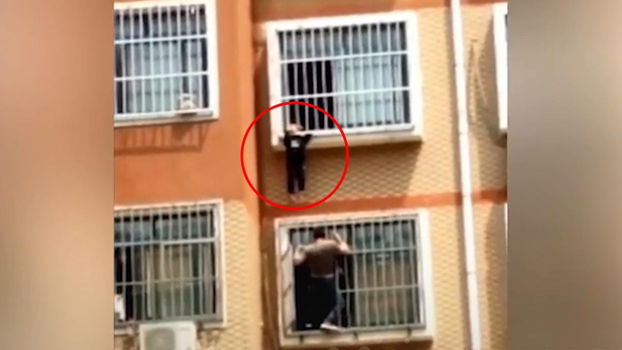 Giai cuu be trai lo lung ngoai ban cong tang 7 hinh anh