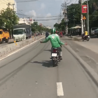 Lai xe may buong hai tay, lang lach nhun nhay giua duong hinh anh