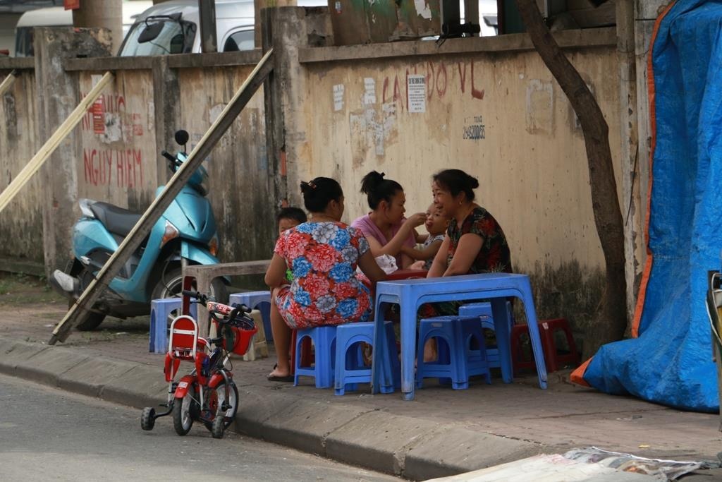 Nguoi Ha Noi ngoi uong tra ben buc tuong sap do hinh anh