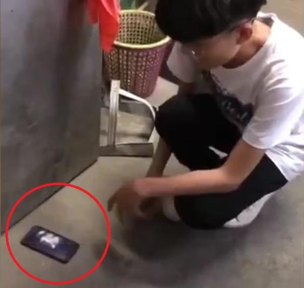 Nam sinh bi phat tu dap nat dien thoai truoc lop vi vi pham noi quy hinh anh