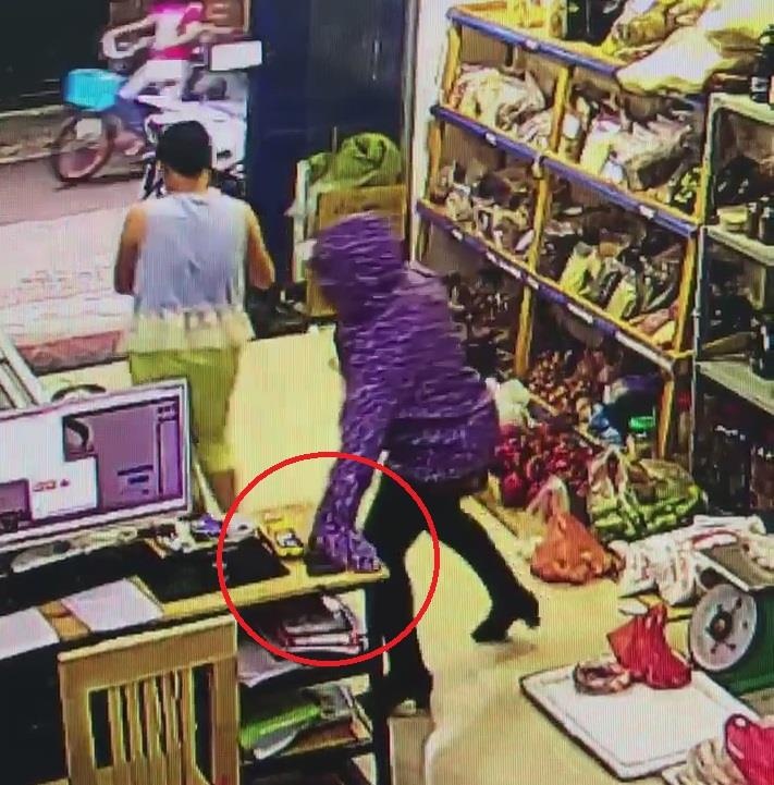 Nguoi phu nu trom dien thoai dat tien ngay trong cua hang o Ha Noi hinh anh