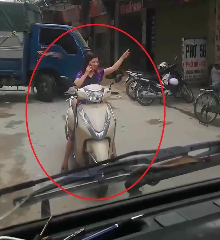 Nguoi phu nu dung giua duong nghe dien thoai khong cho oto di qua hinh anh