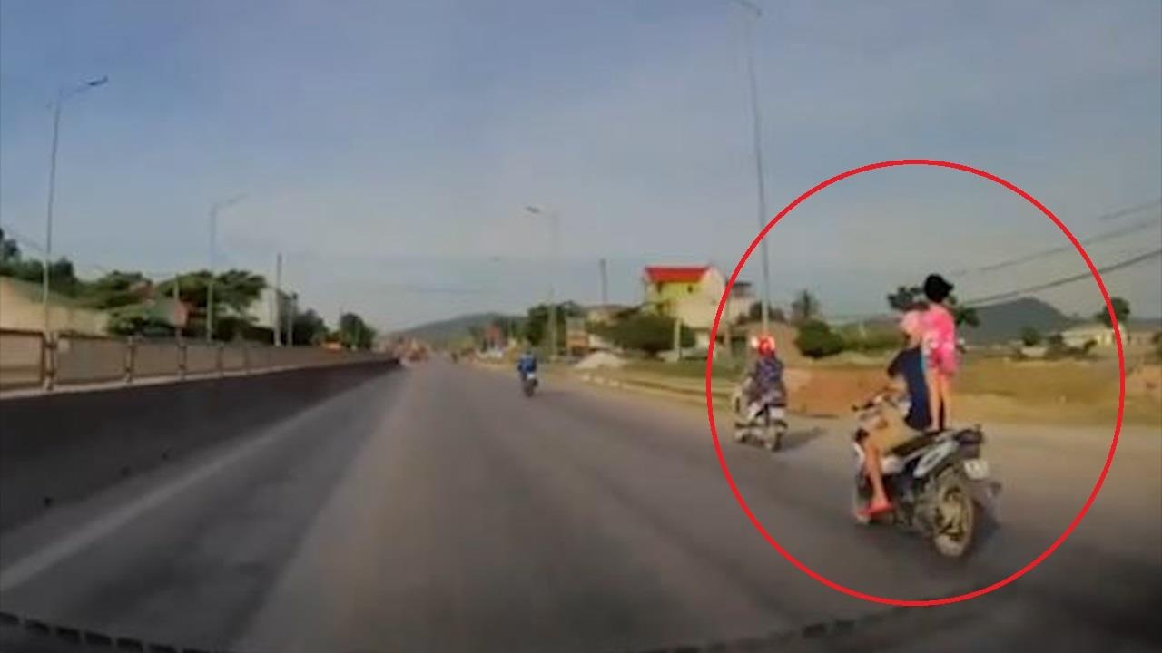 Bo vo tu de con gai dung len yen xe may dang di chuyen voi toc do cao hinh anh