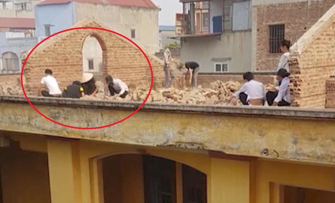 Phat hoc sinh deo gach tren mai nha cao tang hinh anh