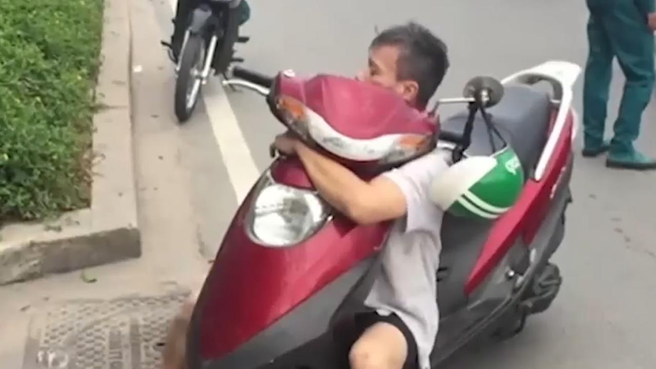 Nguoi dan ong nghi 'ngao da', om chat xe may lac lu tren xa lo hinh anh