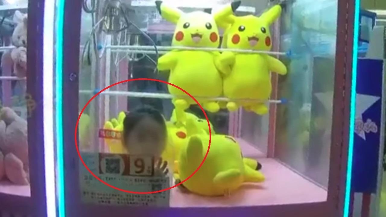 Lay gau bong, be gai mac ket trong may gap thu hinh anh