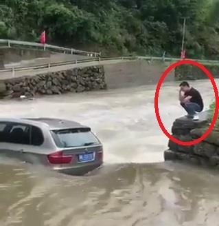 Chu xe ngoi than tho nhin oto ket giua dong nuoc chay xiet hinh anh