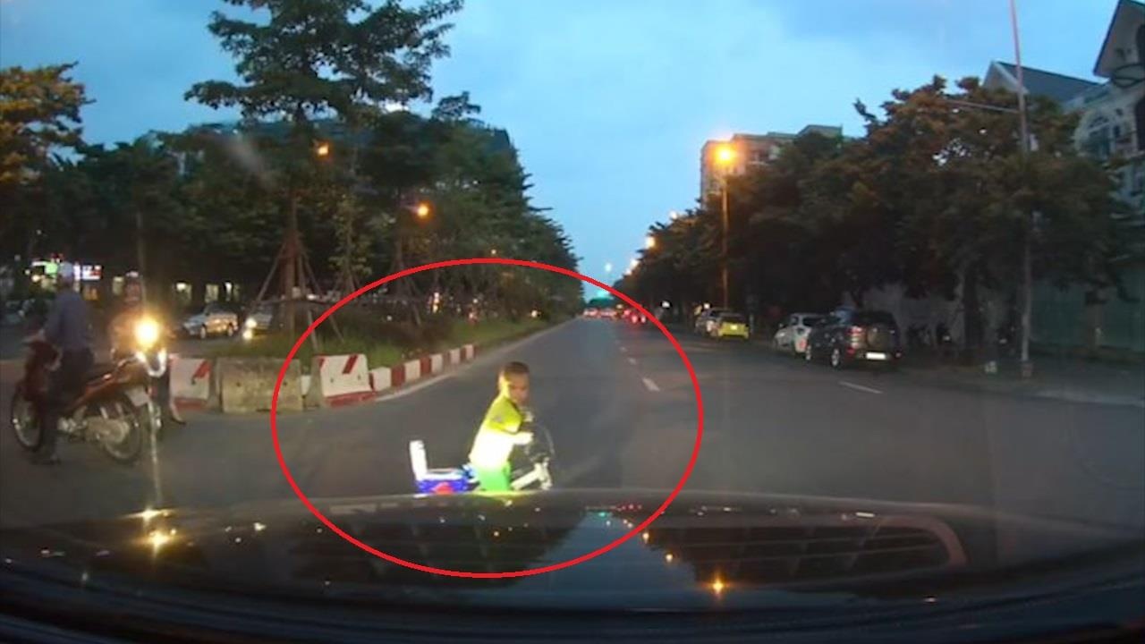 Em be lai xe dap do choi bang qua duong, suyt gap nguy hiem hinh anh