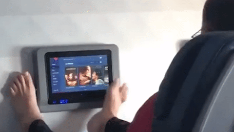 Hanh khach dung chan tran dieu khien man hinh giai tri tren may bay hinh anh