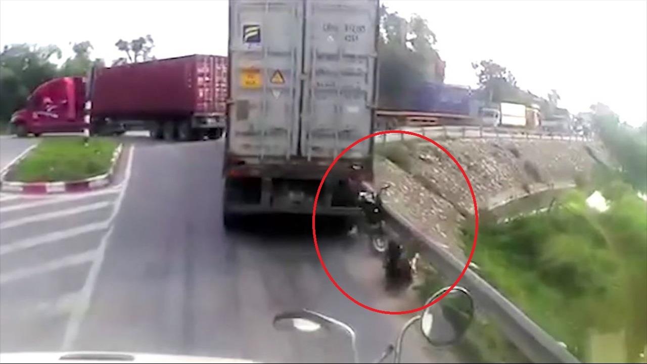 Cho den do ngay diem mu, nu tai xe bi container ep vao lan can hinh anh