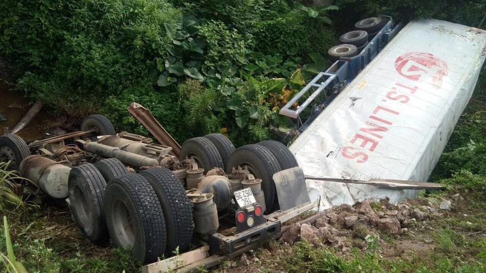 Xe container lao xuong muong lat ngua, 2 nguoi may man thoat nan hinh anh