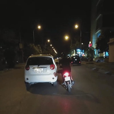 Lai xe may dung chan khong day oto chay bon bon tren duong hinh anh