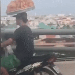 Tai xe xe may doi khay banh mi than nhien luu thong tren duong hinh anh